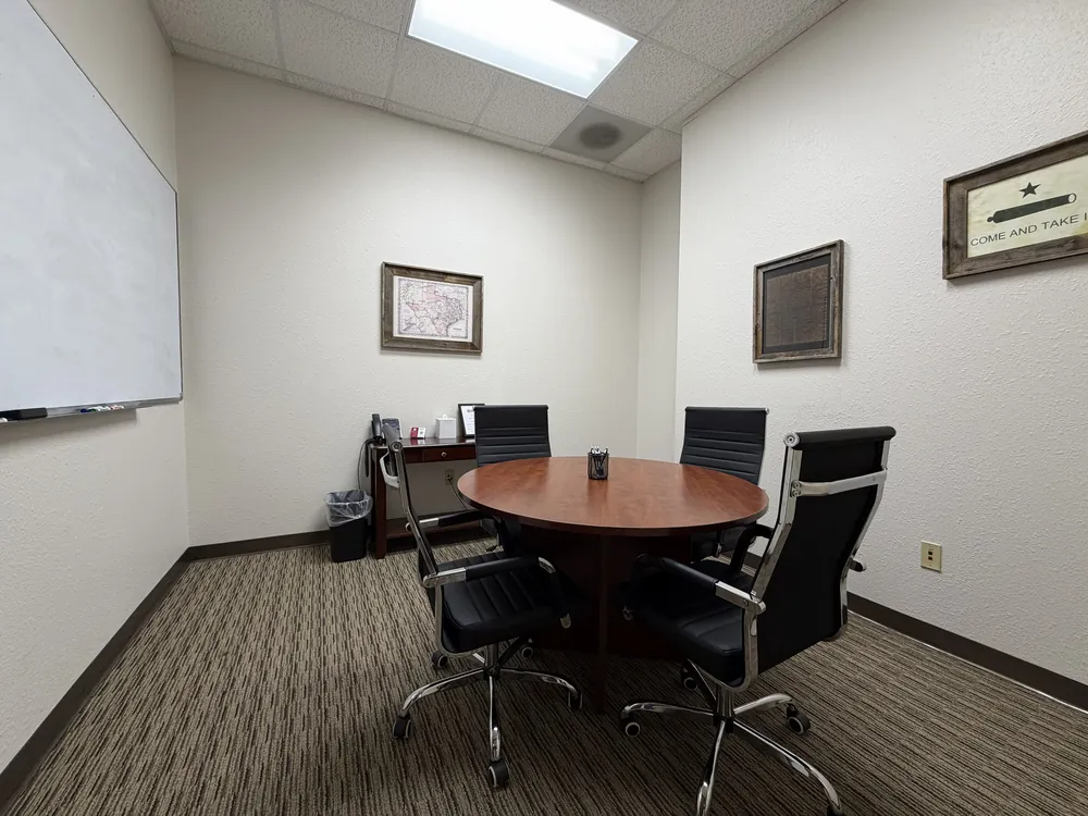 Pecan meeting room with a round table and whiteboard at Heritage Office Suites Round Rock